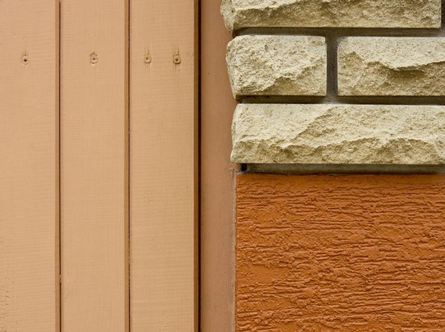Siding material swatches in a close-up layout featuring brick, stucco texture, and wood plank surfaces