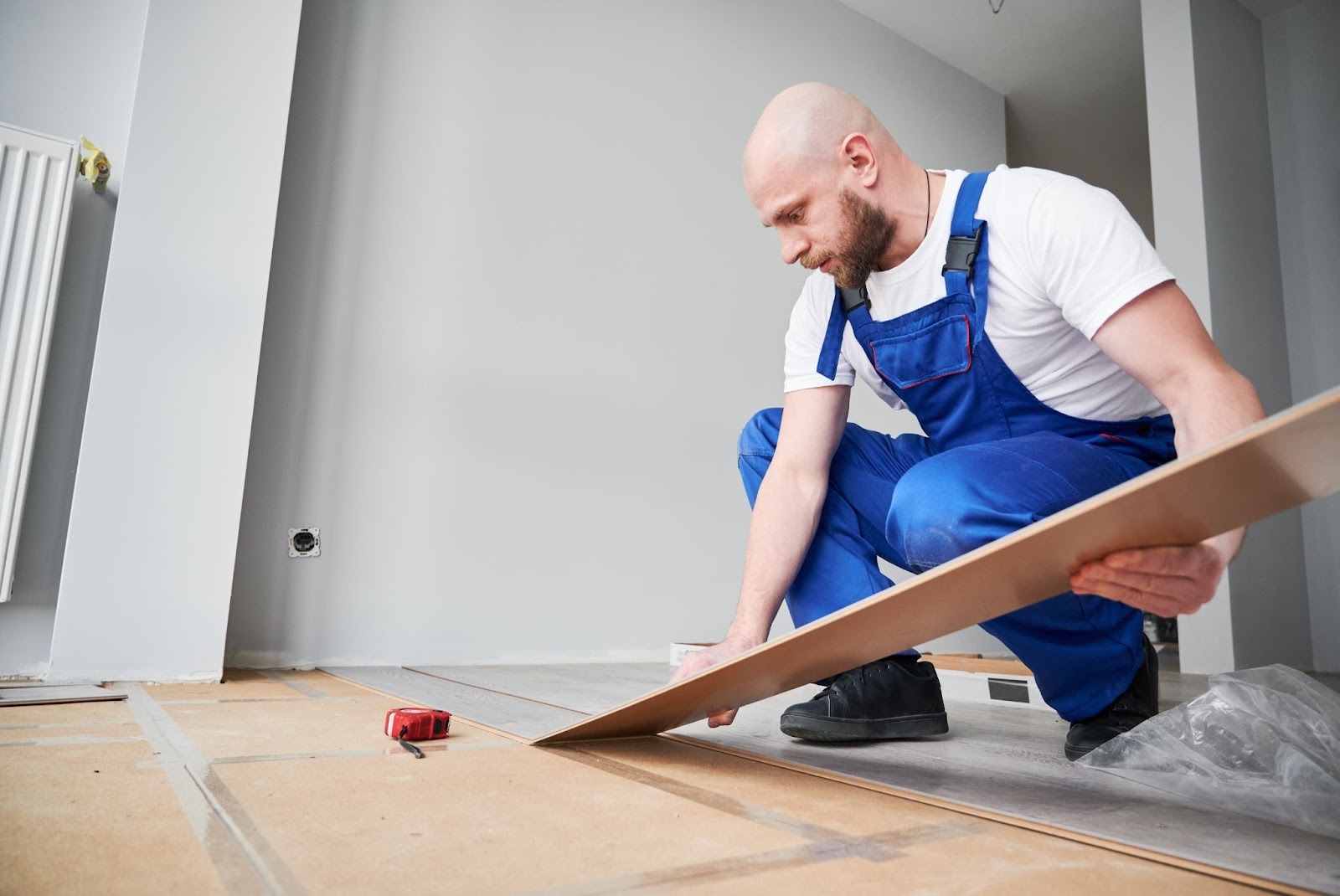 Professional flooring contractor laying laminate planks in a renovated living space