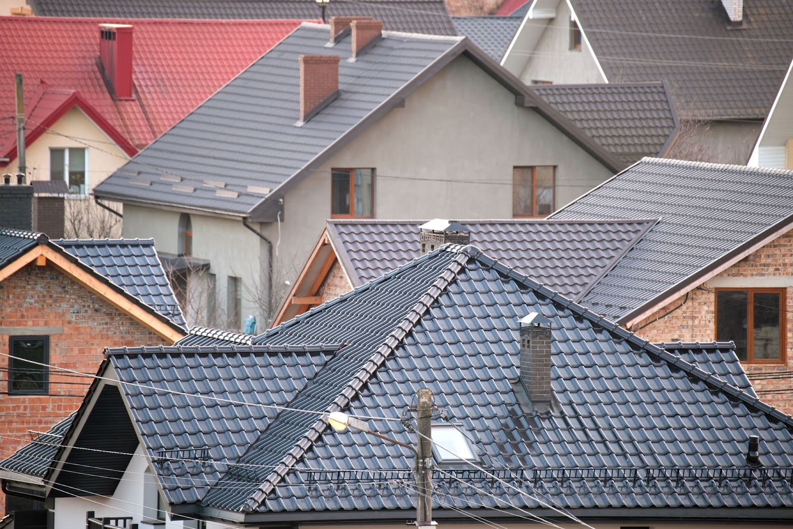 Residential homes featuring metal roofing panels and ceramic tile shingles