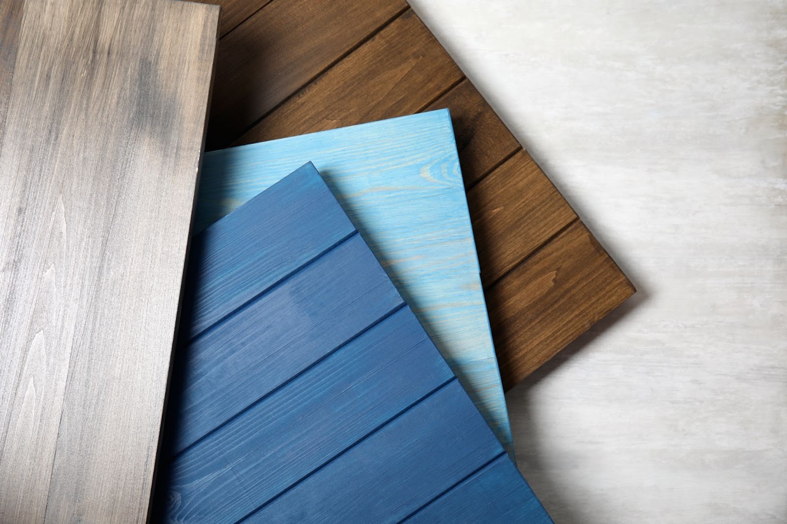 Multiple wooden siding materials displayed with varied grain textures for home exterior cladding